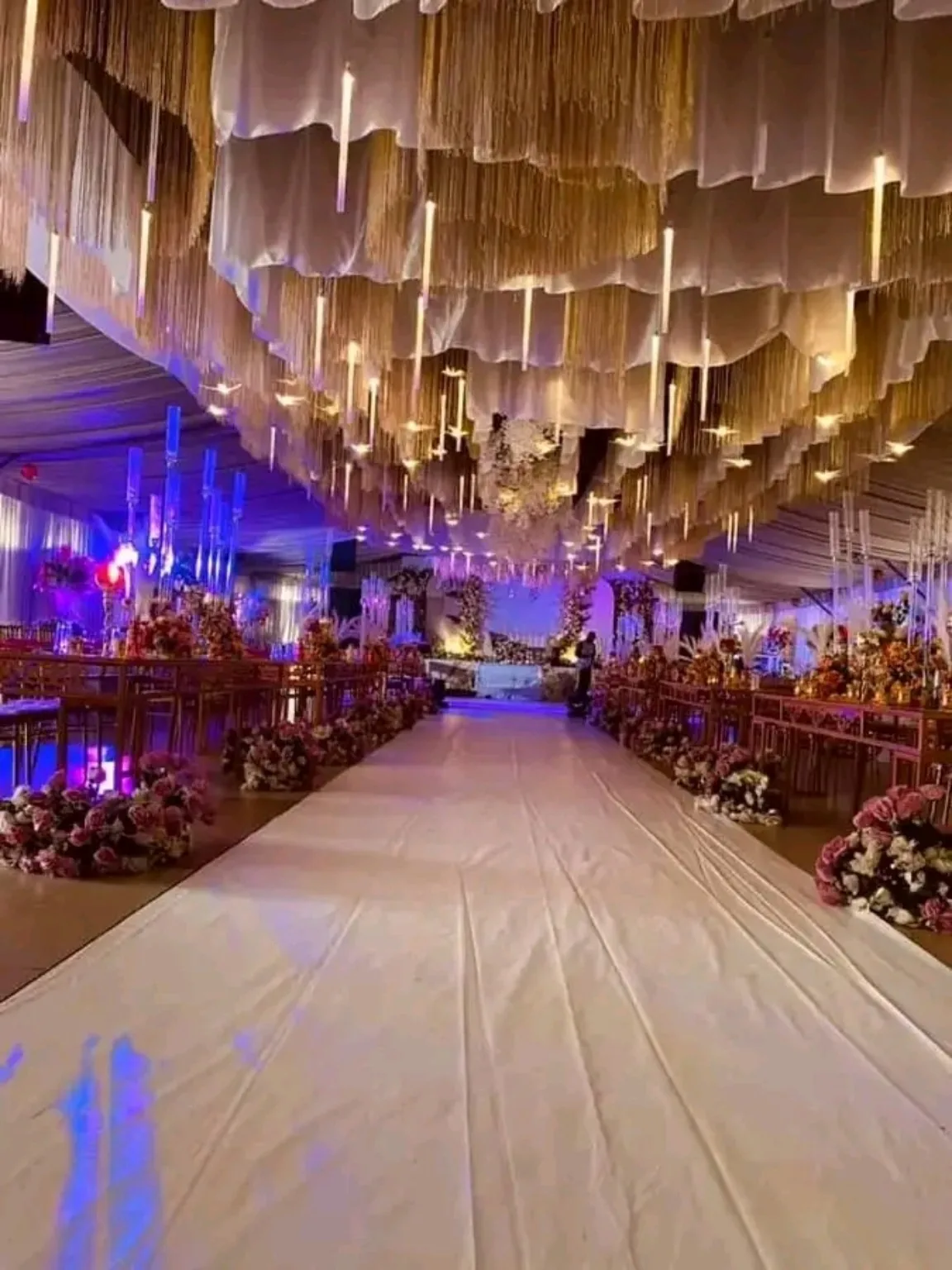 Reception venue with an illuminated aisle and elegant ceiling décor
