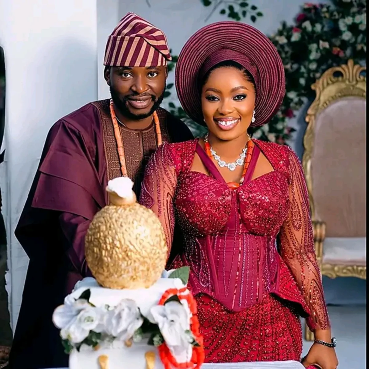 Couple celebrating in elegant burgundy traditional attire